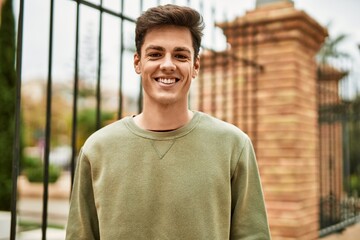 Obraz premium Young hispanic man smiling happy standing at the city.