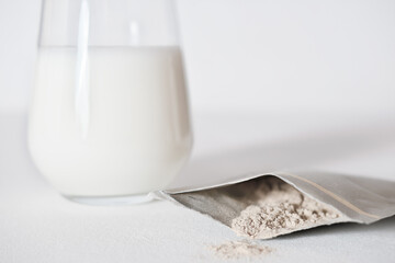 hand holding collagen powder travel pack and adding it to a milk to make protein cocktail. collagen...