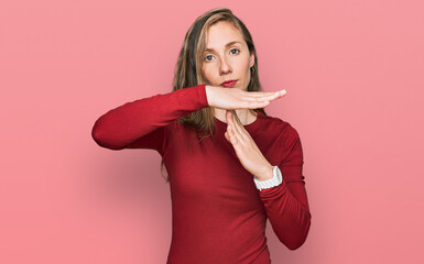 Young blonde woman wearing casual clothes doing time out gesture with hands, frustrated and serious...