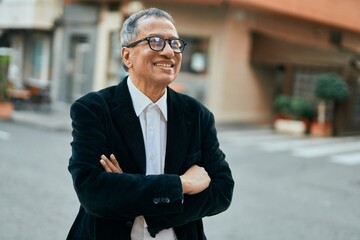Middle age southeast asian man smiling confident with crossed arms at the city