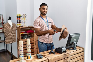 Young arab man smiling confident working at clothing store