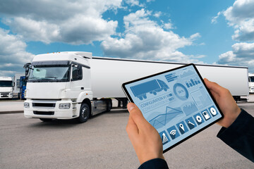 Manager with a digital tablet on the background of truck. Fleet management	
