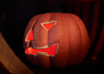 A glowing carved pumpkin in a dark background - halloween concept