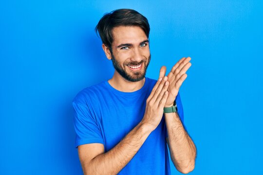 Young hispanic man wearing casual clothes clapping and applauding happy and joyful, smiling proud hands together