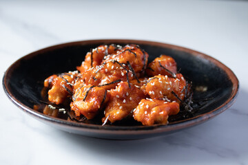 Fried chicken with Korean spicy sauce topped with seaweed