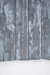 blue wood texture background with untouched snow, peeling paint on wood in winter