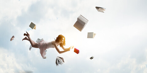 Young woman levitates while reading a book