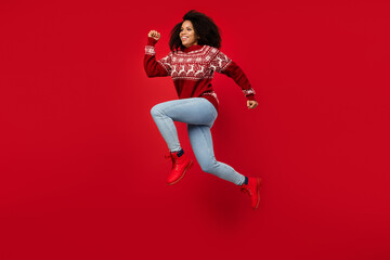 Photo of sweet pretty woman dressed print sweater smiling jumping high running fast isolated red color background