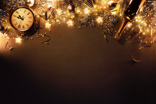 New Years Eve holiday background with fir branches, clock, christmas balls, champagne bottle, gift box and lights