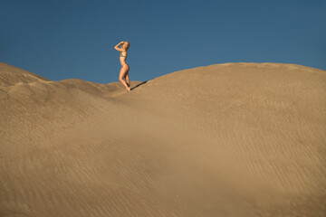 Fototapeta na wymiar sporty woman in a swimsuit on the sand