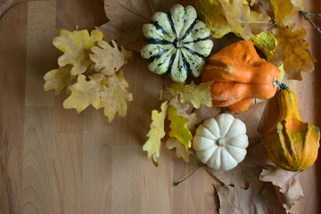 Decorative pumpkins: autumn leaves on wooden background 03