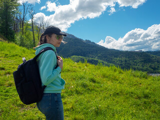 Local tourism, hiking in the mountains. A young woman tourist with a backpack
