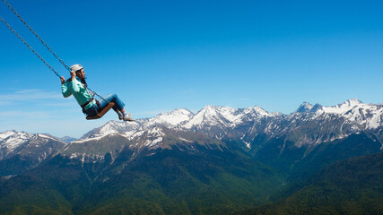 Naklejka na ściany i meble Flying on a mountain swing, entertainment in nature