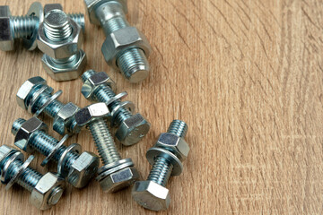 a few nuts and bolts on a wooden surface. copy space