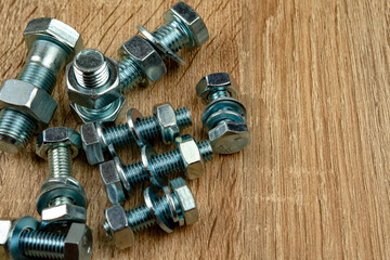 a few nuts and bolts on a wooden surface. copy space