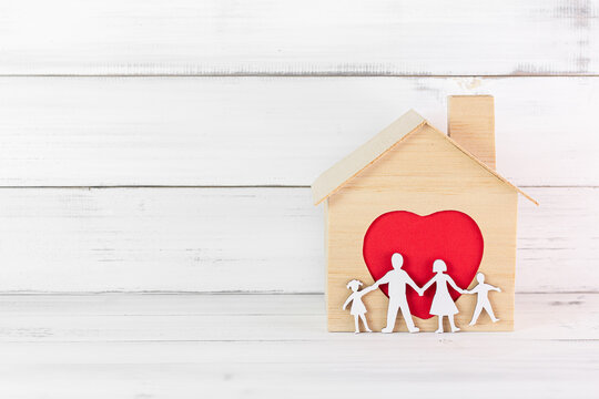 Wooden House with red heart outline in house over white wood background. Happy Family Concept with Copy Space.