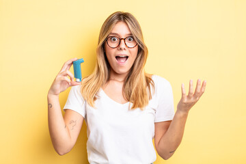 pretty blonde girl feeling happy, surprised realizing a solution or idea. asthma inhaler concept
