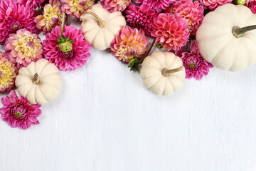 Colorful dahlia flowers and white baby boo pumpkin on wooden background.