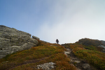 A man climbs to the top of the mountain. Hiking background