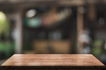 Empty wooden table top with lights bokeh on blur restaurant background.