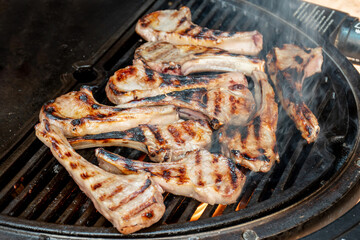 Lamb cutlets chops grilling on barbecue plate . Backyard BBQ grill cooking. Australia Day celebration