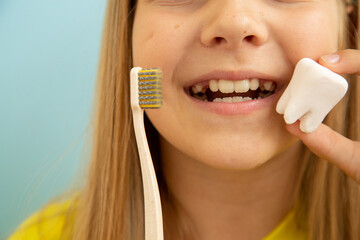 girl on a blue background with a toothbrush and teeth smiling, dentistry and brushing teeth	 - obrazy, fototapety, plakaty