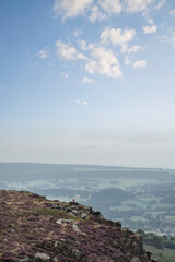 Beautiful colorful English Peak District landscape from Curbar Edge of colorful heather during late Summer sunset