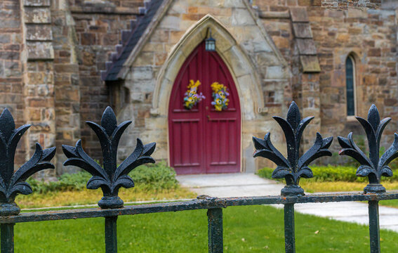 Fototapeta Red Front door of a Church.  One missing fence finial leaves room for the door to be seen clearly.  Autumn Decorations adorn these Red Wooden Doors.  Chenango, Broome County Upstate NY