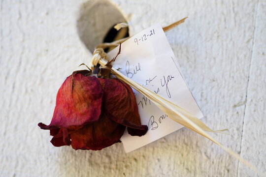 The rose and love letter are tacked on to the wooden bridge.
