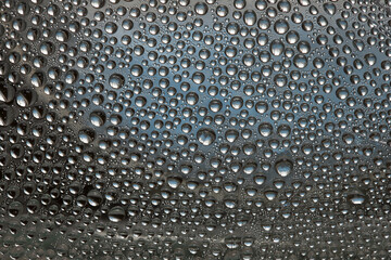 Drops of water of silver-blue colors are located on a silver-blue background. Abstract fantasy. 3D render.