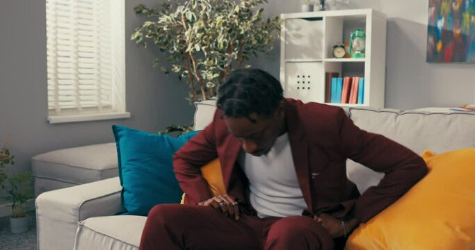 Distraught, sad bisnessman dressed in a suit sits on sofa in office covers face with hand, crying business collapse loss of money failure at work dark-skinned man is worried having worse day stress