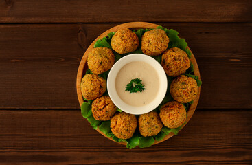 Falafel balls, with tahini sauce, on a wooden board, vegetarian food, homemade,