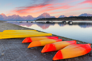 Overview of Jackson Lake with colorful boats in foreground before sun rise viewing from signal Mountain campground at Grand Teton National Park, Wyoming USA.