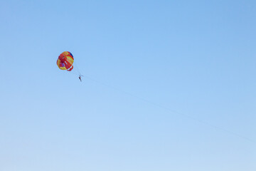 Parasailing water amusement - flying on a parachute behind a boat on a summer holiday by the sea in the resort