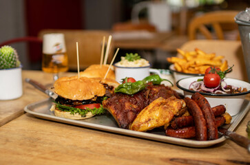 BBQ im Restaurant mit Burgern, Spareribs, Chicken Wings, Pommes und Wurst