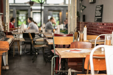 Fototapeta na wymiar urbanes Restaurant in Großstadt mit vintage Möbeln und Gästen im Hintergrund