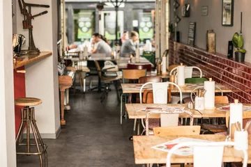 Deurstickers urbanes Restaurant in Großstadt mit vintage Möbeln und Gästen im Hintergrund © creativemariolorek