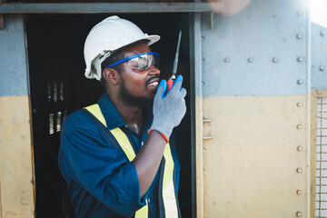 African engineer wears safety glasses, helmets and gloves to prevent accidents while working with...