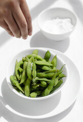 edamame beans snack in bowl on table with sea salt