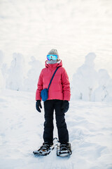 Fototapeta na wymiar Cute girl hiking in snowshoes