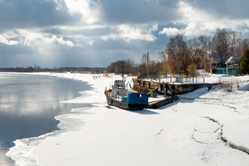 Winter view of the Volga river in the city of Kimry and a ship wintering near the shore
