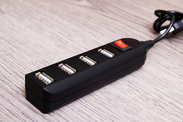 Black USB hub on a wooden background