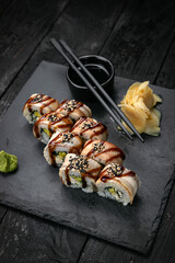 Japanese rolls on a dark plate in a restaurant
