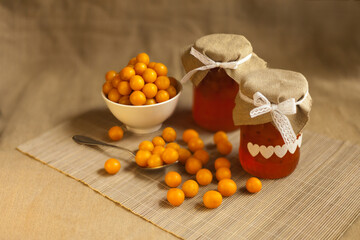 cherry plums yellow Jam, fresh berries fruits. homemade marmalade in glass jar on brown textile background