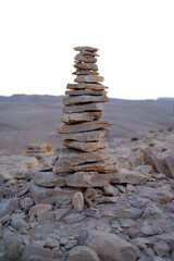Fototapeta na wymiar Cairn at sunrise, stones balances, pyramid of stones at sunset, concept of life balance, harmony and meditation. A pile of stones in desert mountains, crater Ramon, Israel. stack of rocks, stone tower