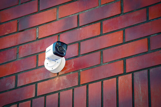 Minsk,Belarus. Feb 2021. Hikvision new video surveillance camera mounted on red brick wall. Hikvision - Chinese manufacturer and largest supplier of video surveillance products in the world