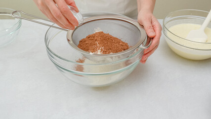 Chocolate cake step by step recipe. Mixing dry ingredients - flour, cocoa powder, baking powder - in a glass bowl