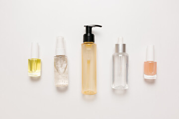 Organic cosmetics packaging design. Flat lay, top view clear glass pump bottle, brush jar, moisturizing serum jar on a white background. Natural cosmetics SPA