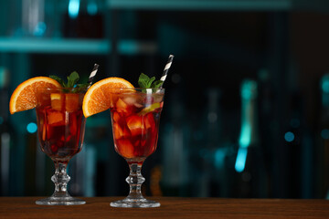 Delicious sangria cocktail on wooden table in bar. Space for text