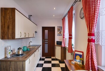 Stylowy salon z kuchnią z czerwonymi zasłonami